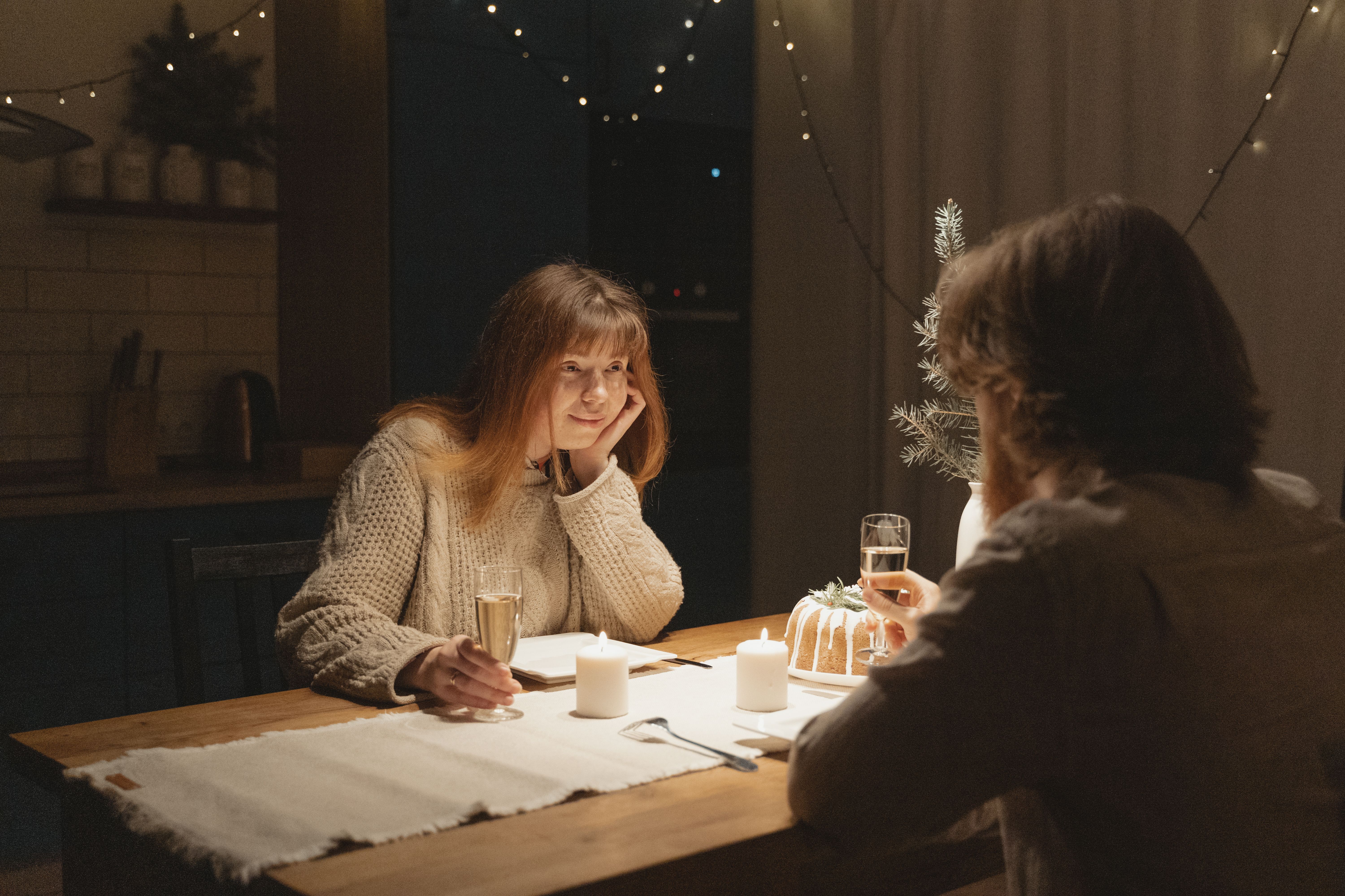 Cozy candlelit dinner scene with a couple enjoying a romantic evening indoors, creating space for presence and ritual