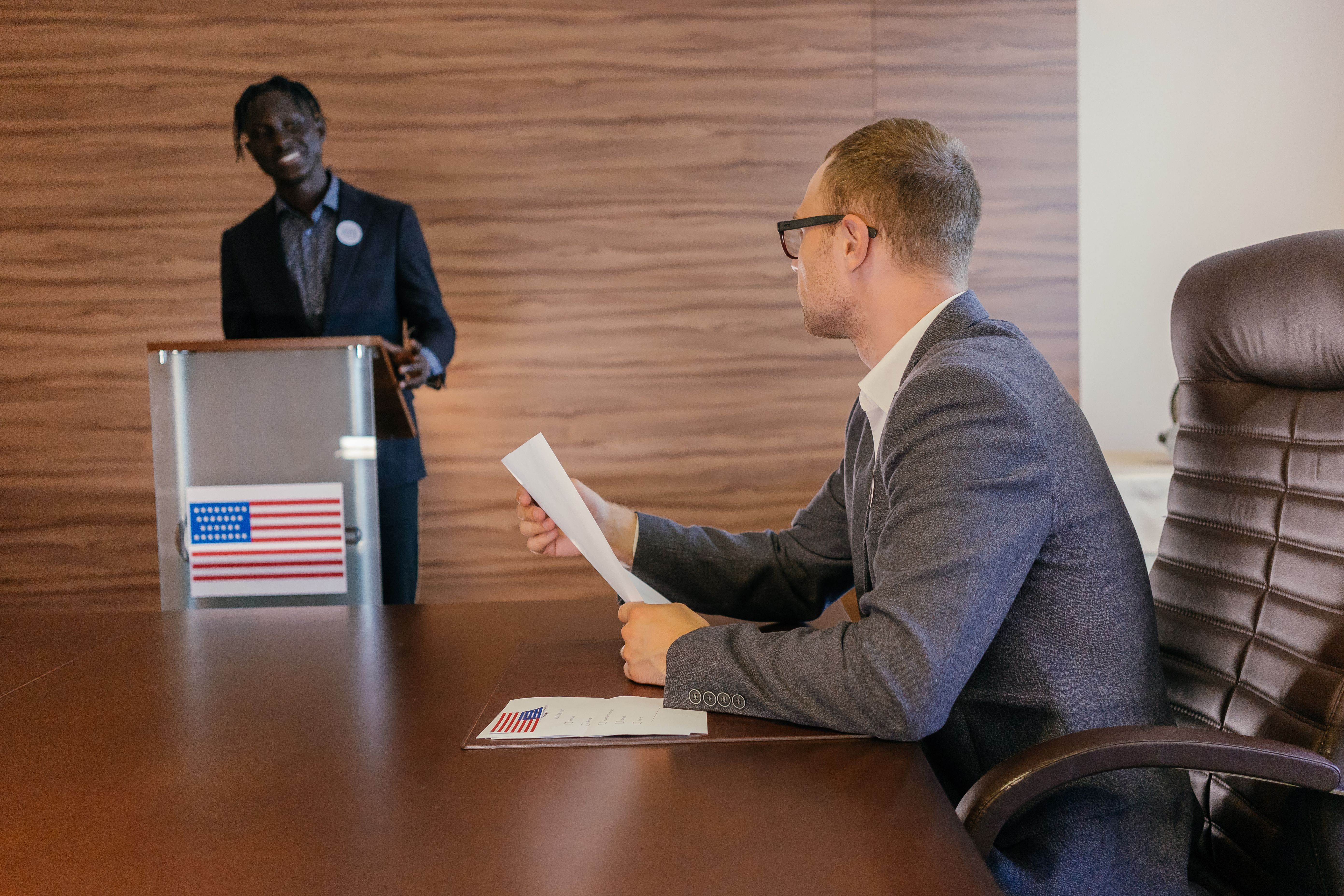 Two ministers in discussion during a cabinet reshuffle meeting
