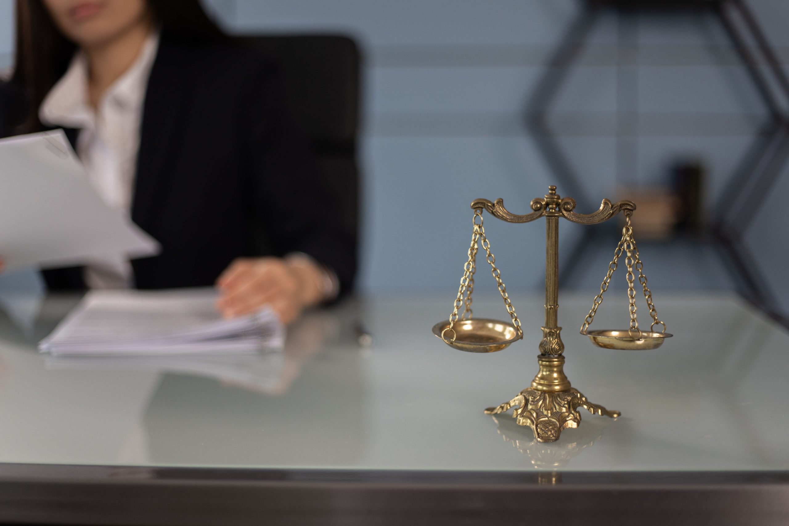 Balance scales of justice on a desk, representing fairness and legal responsibility for civil lawsuit costs.