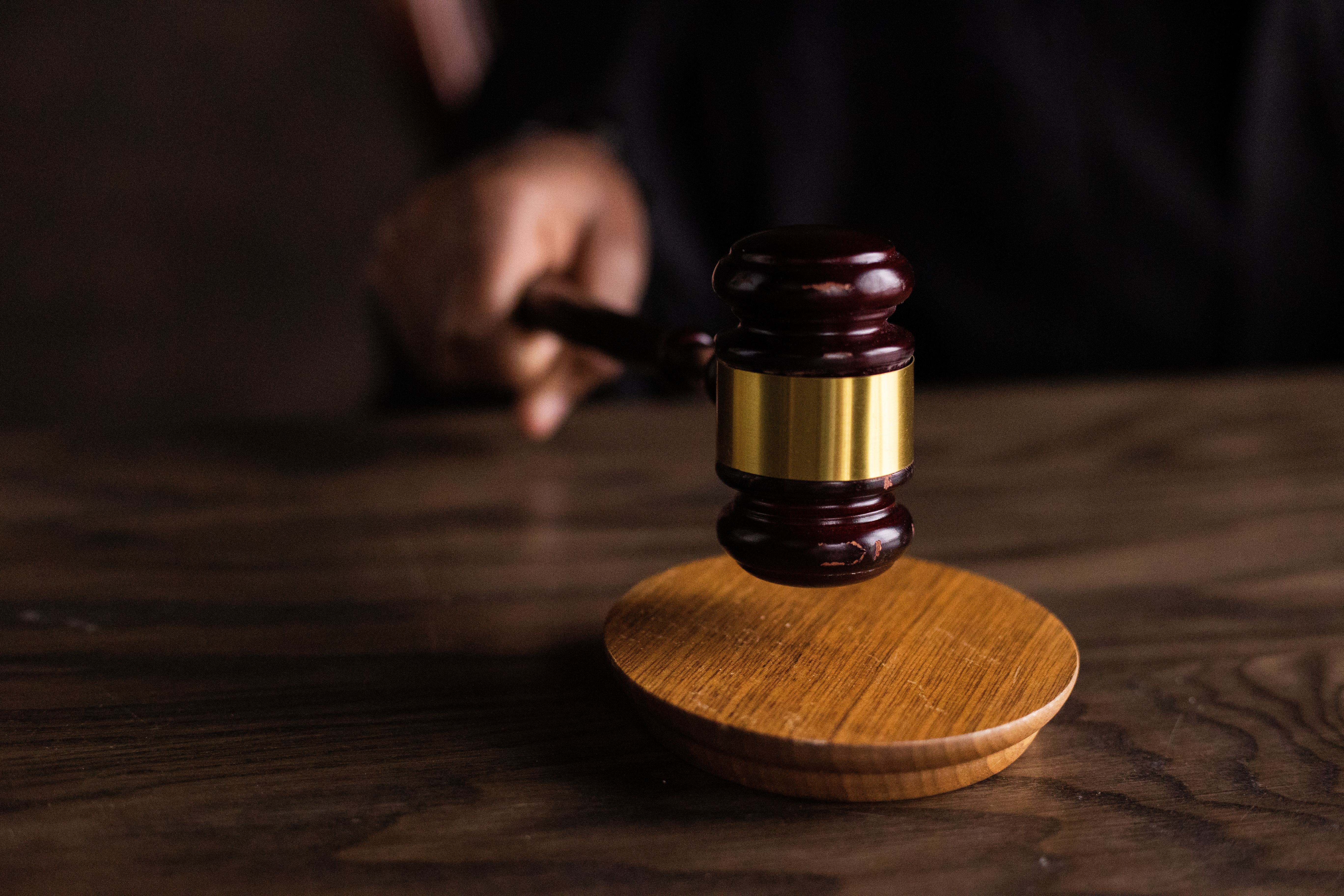A gavel striking a sound block in a courtroom representing long litigation