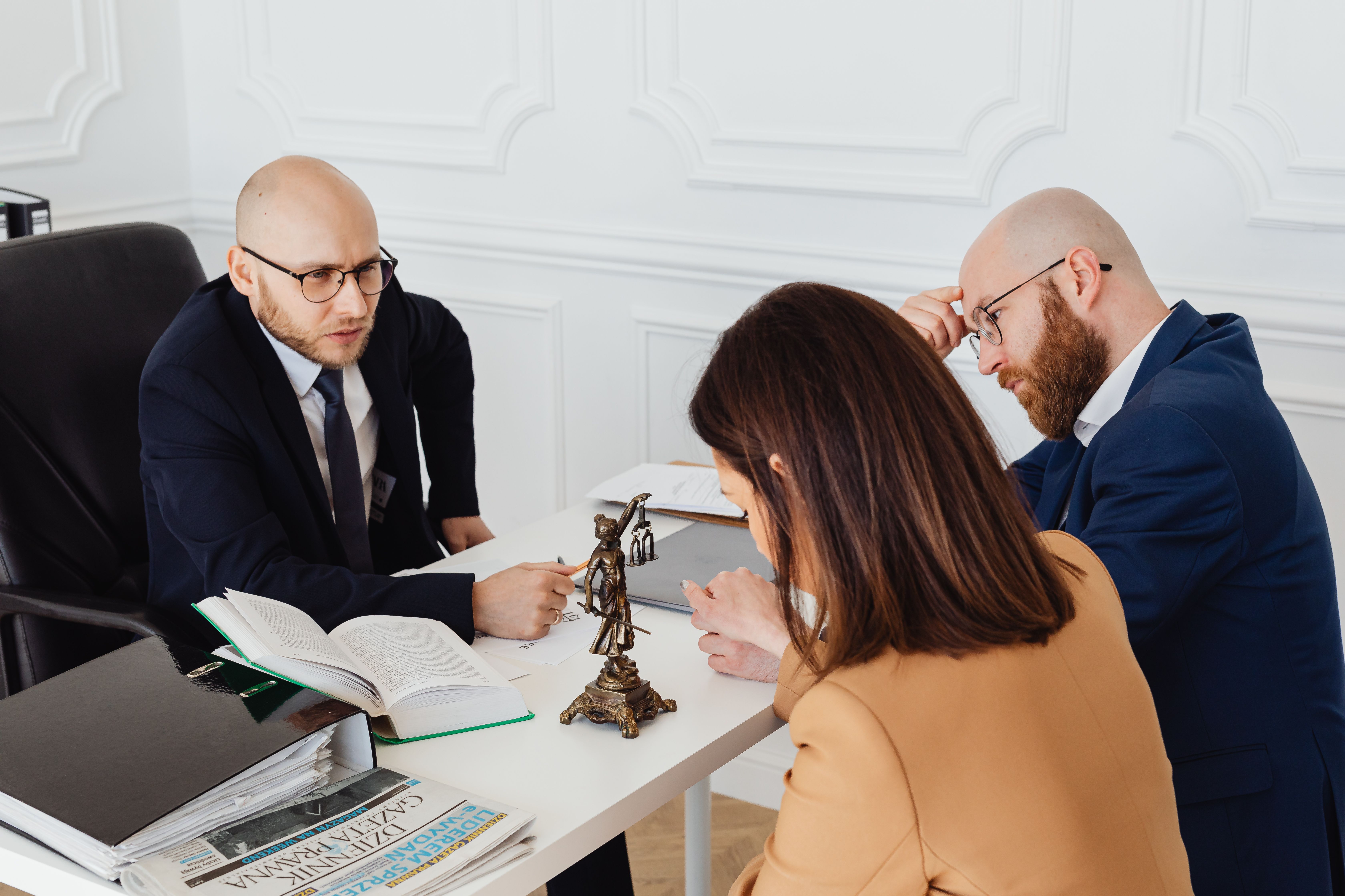 Lawyer consulting clients in a modern office about a legal matter.