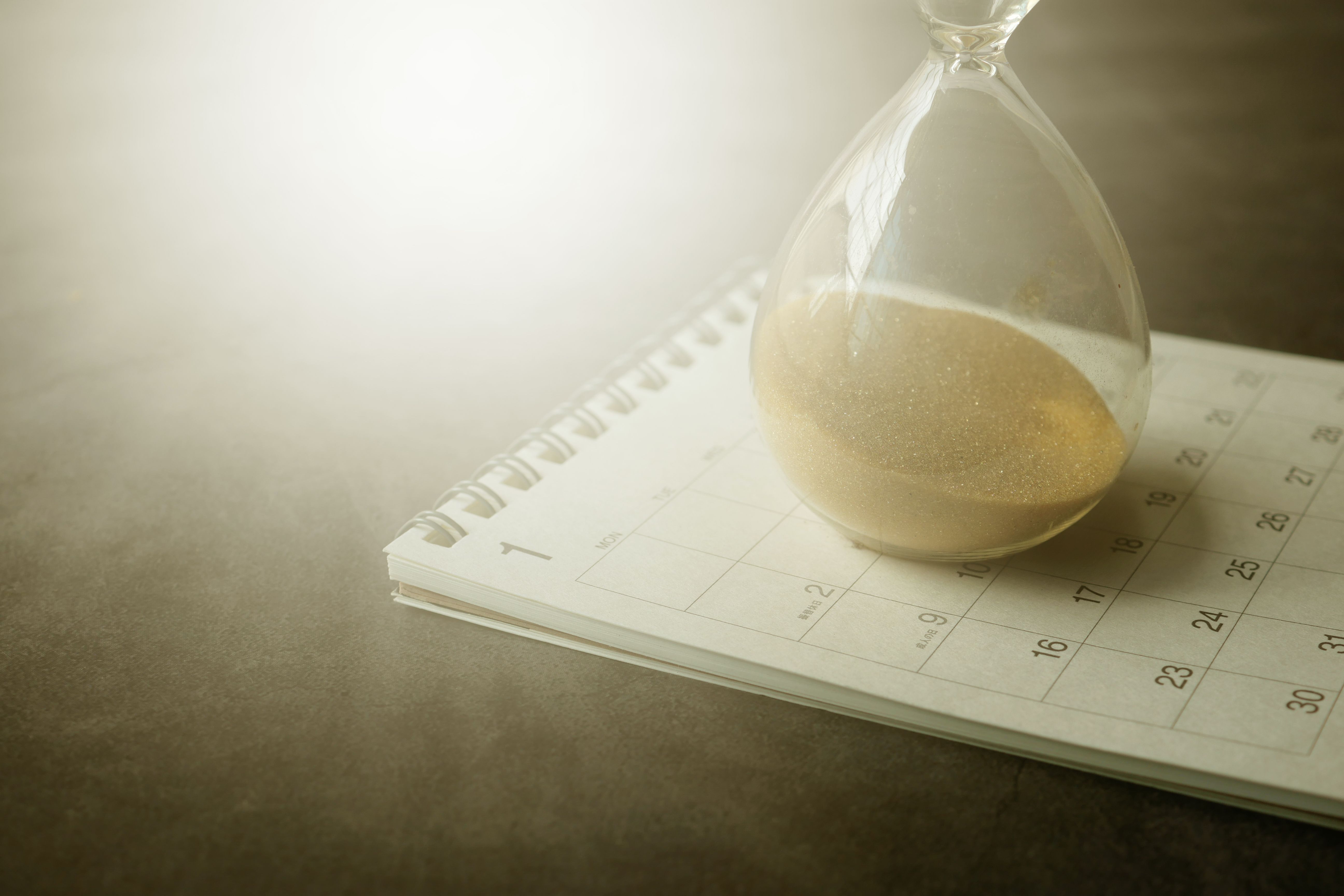 An hourglass on a calendar symbolizing the long timeline of a drawn-out legal case